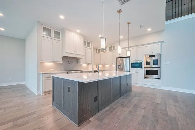 a large kitchen with kitchen island a sink stainless steel appliances and cabinets
