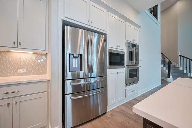 a kitchen with stainless steel appliances a refrigerator microwave and sink