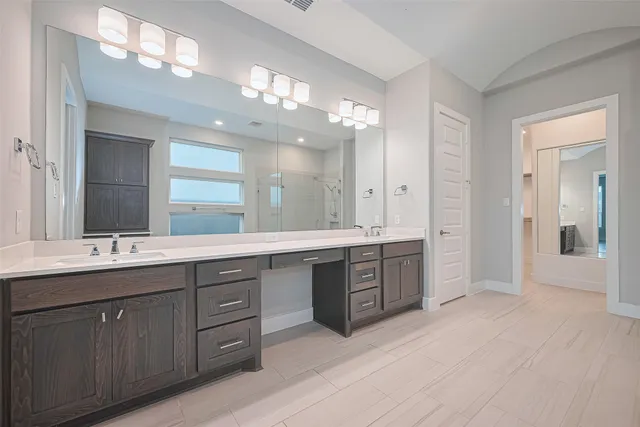 a large bathroom with a double vanity sink a large mirror and shower