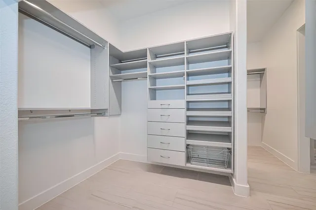 a view of walk in closet with empty racks