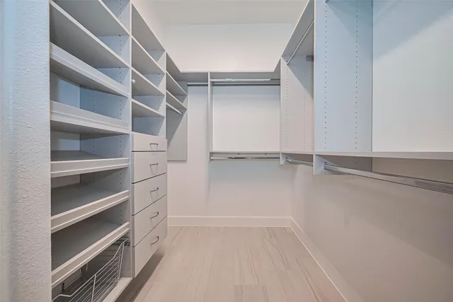 a view of walk in closet with empty racks