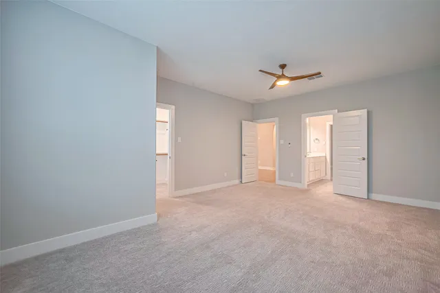 an empty room with an entryway and fan