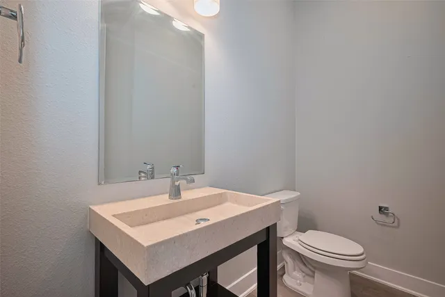 a bathroom with a sink a toilet and a mirror