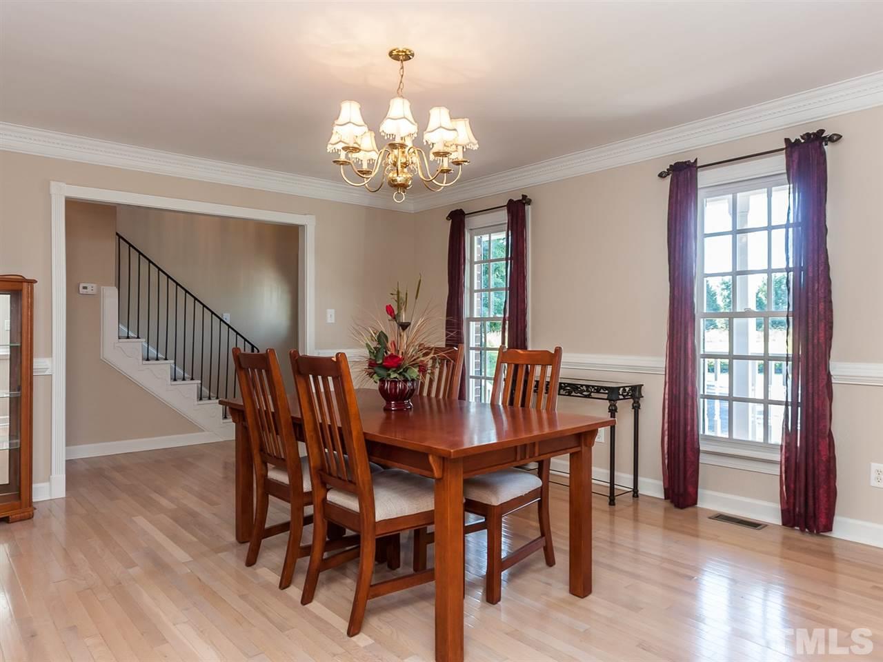 3128 Sanders Road Willow Spring, NC 27592 - Photo 3 of 25 a view of a dining room with furniture a chandelier and wooden floor