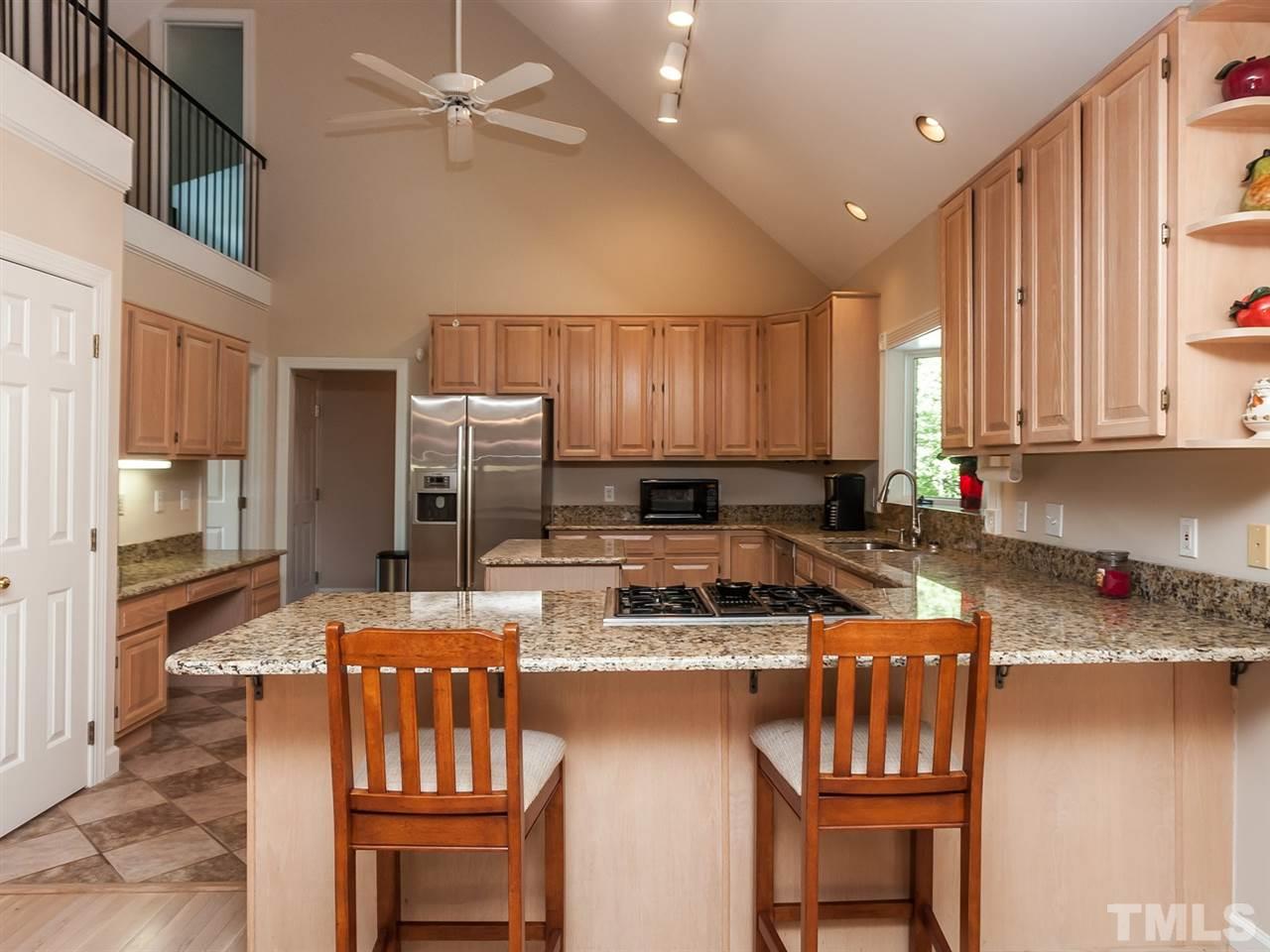 3128 Sanders Road Willow Spring, NC 27592 - Photo 25 of 25 a kitchen with a stove a sink a microwave a refrigerator and chairs