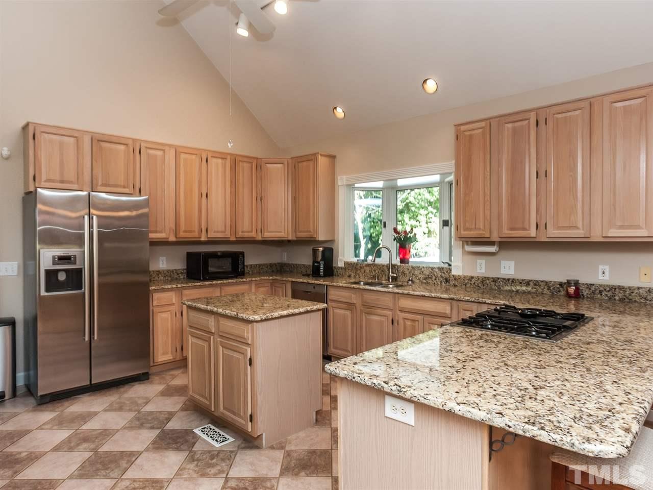 3128 Sanders Road Willow Spring, NC 27592 - Photo 5 of 25 a kitchen with a sink a stove a refrigerator and cabinets