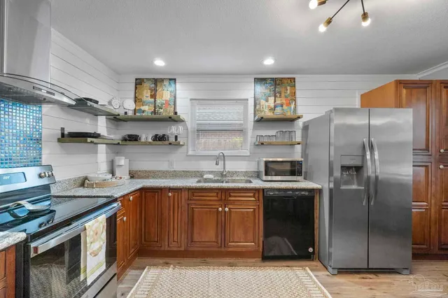 a kitchen with stainless steel appliances granite countertop a sink stove and refrigerator