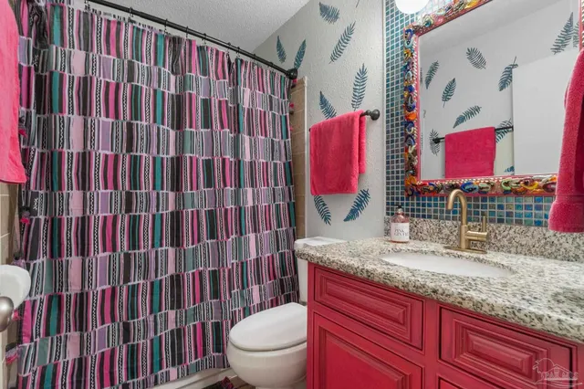 a bathroom with a sink toilet and shower curtain