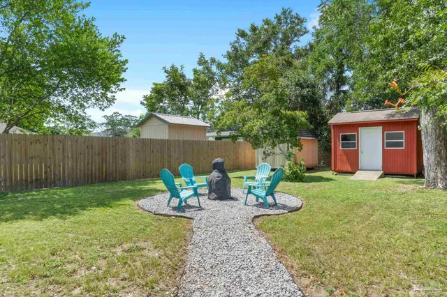 a view of a backyard with table and chairs and wooden fence