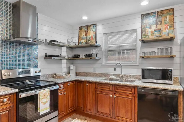 a kitchen with stainless steel appliances granite countertop a stove a sink and a microwave