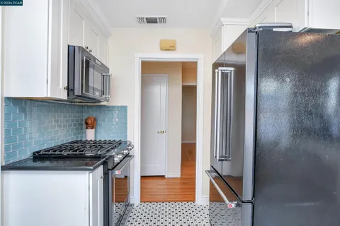 a kitchen with a refrigerator and a stove top oven