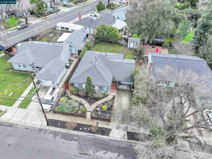 an aerial view of a house with a yard and street