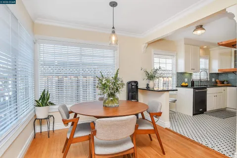 a kitchen with a dining table chairs and white appliances