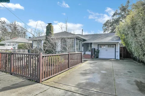 a view of a house with a large window and wooden fence