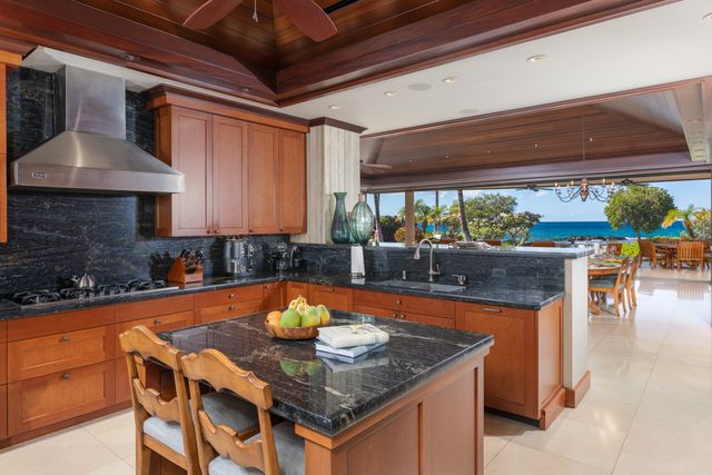 a kitchen with stainless steel appliances granite countertop a sink a stove and a wooden floors