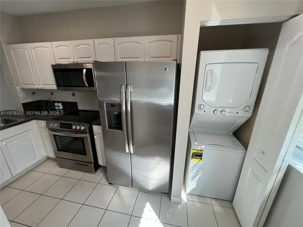 a kitchen with stainless steel appliances granite countertop a refrigerator a stove and a sink