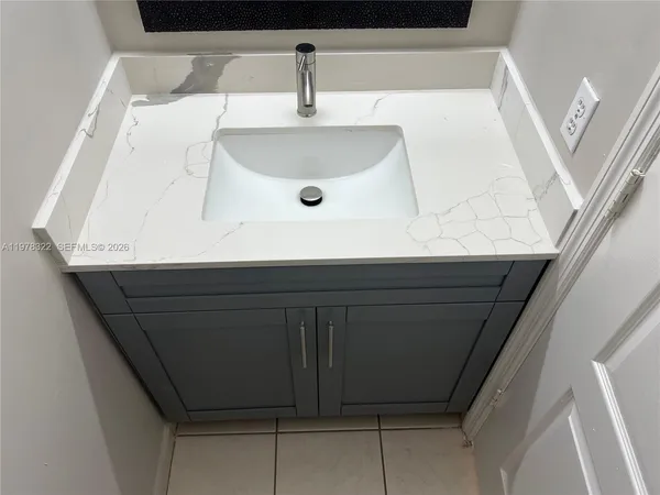 a view of an empty room with a chandelier fan