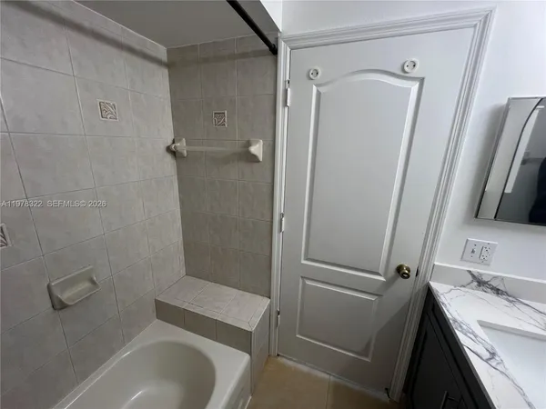 a bathroom with a granite countertop toilet sink and shower