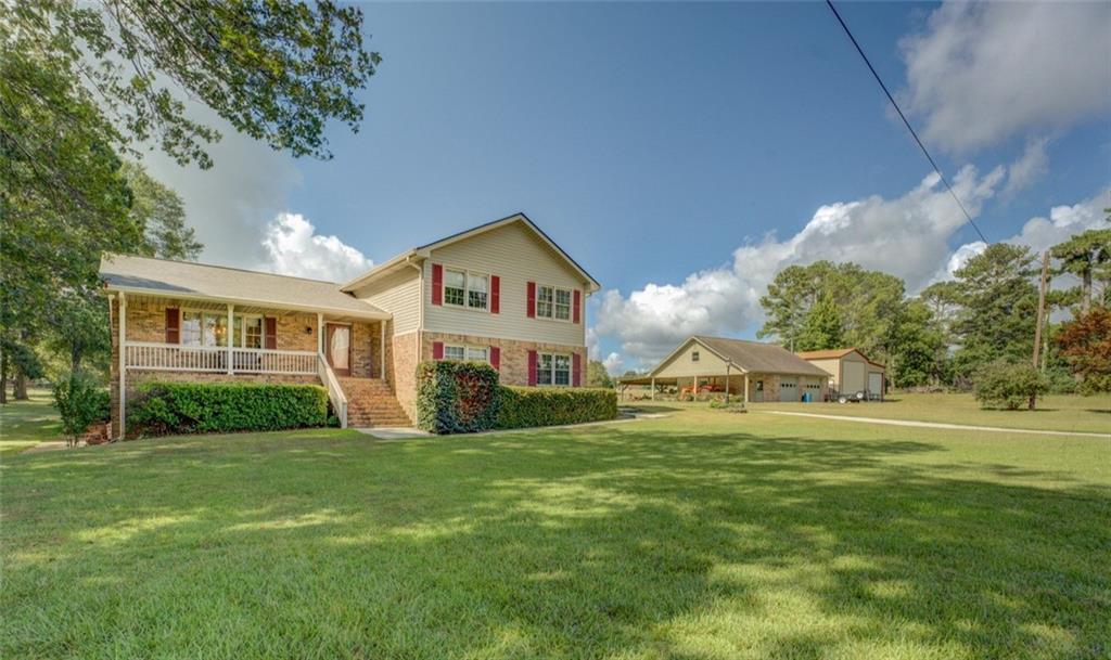 a view of a house with a big yard and large trees