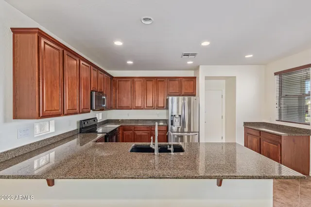 a kitchen with stainless steel appliances granite countertop a refrigerator sink and cabinets