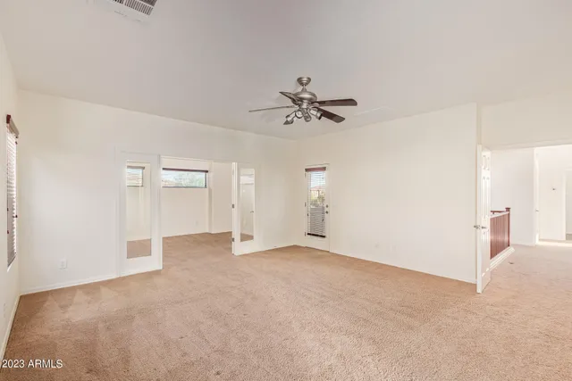 an empty room with fan and windows