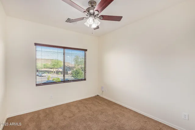 an empty room with a chandelier fan and a fan