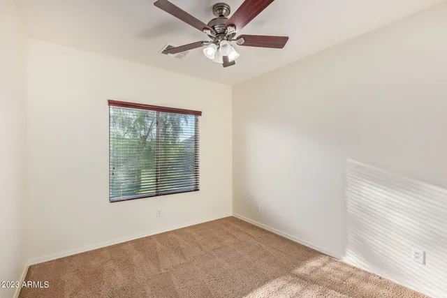 a view of a room that has a bed and a chandelier fan