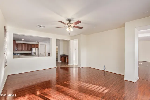 a living room with hard wood floors and a ceiling fan