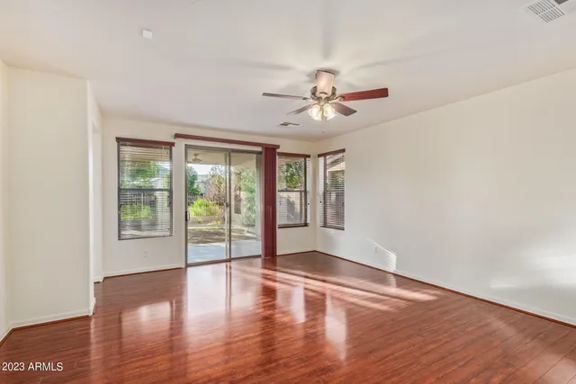 a view of an empty room with a window and wooden floor