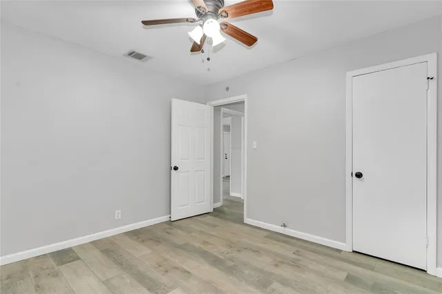 an empty room with closet and a chandelier fan