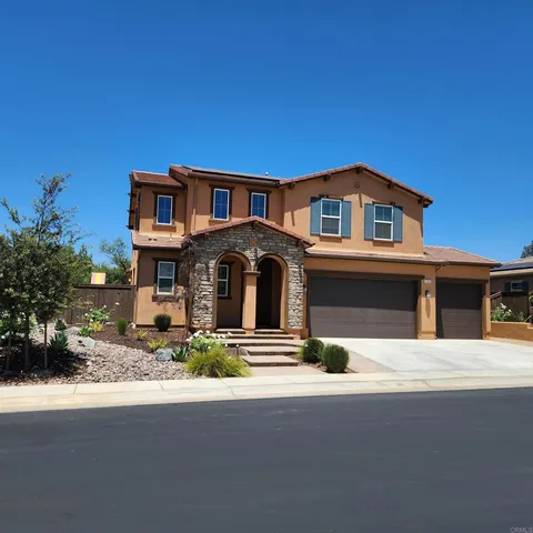 a front view of a house with yard and parking