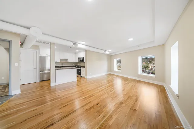 a view of a kitchen with wooden floor and a refrigerator