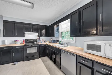 a kitchen with a sink stove top oven and microwave