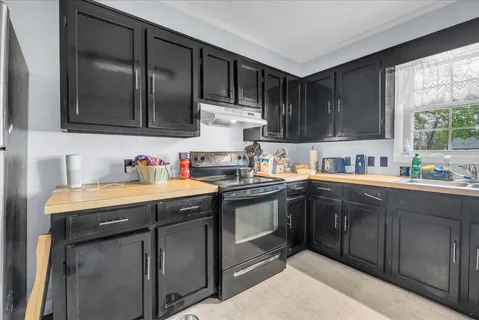 a kitchen with stainless steel appliances granite countertop a sink stove and cabinets