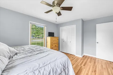 a bedroom with a bed ceiling fan and a window