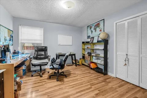 a view of a workspace with furniture and a window