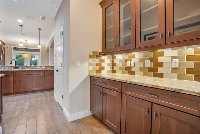 a view of a hallway with windows and chandelier