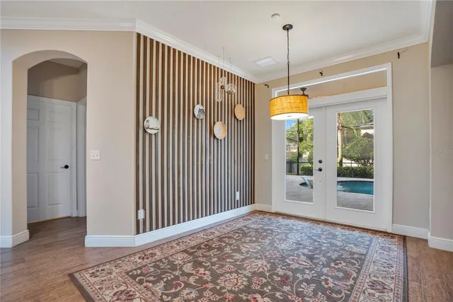 an empty room with wooden floor a ceiling fan and kitchen view