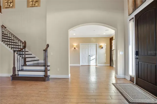 a view of a hallway with wooden floor and staircase