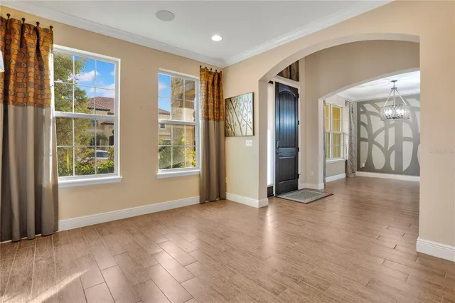 a view of an empty room with glass door and wooden floor