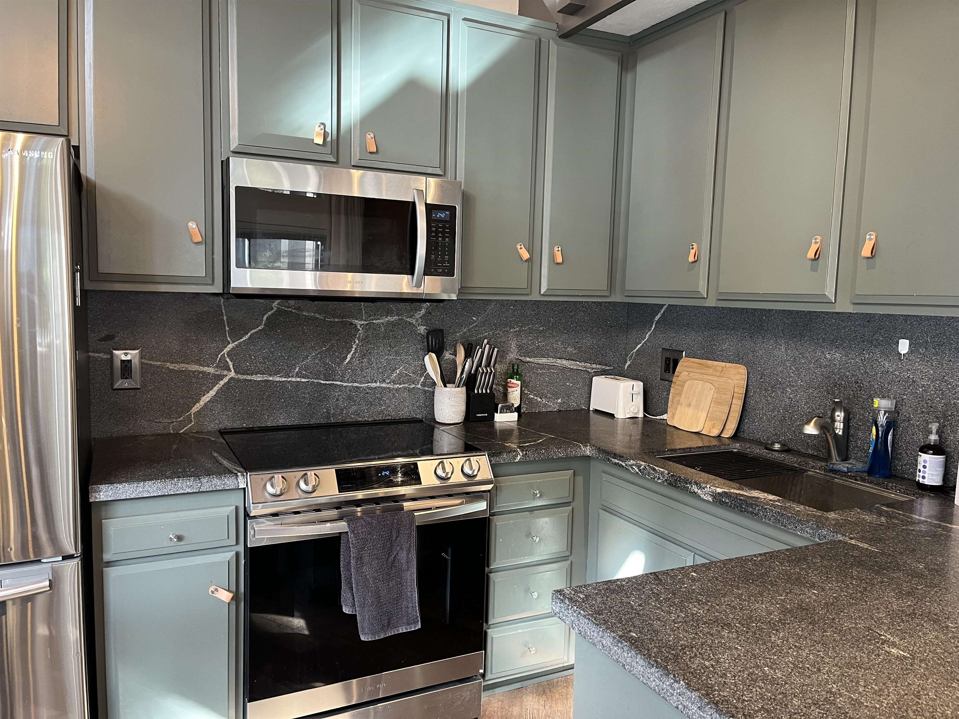 286 Old Mammoth Road, Unit 7 Mammoth Lakes, CA 93546 - Photo 11 of 32 Kitchen featuring stainless steel appliances, tasteful backsplash, dark stone counters, and gray cabinetry