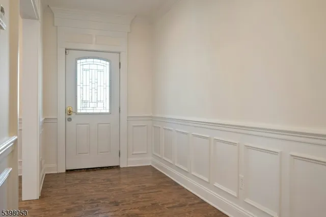 a view of an empty room with closet and a window