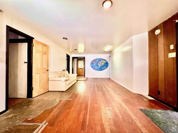 a view of a hallway with wooden floor and staircase