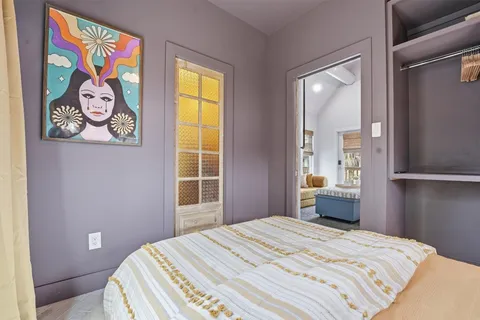 a bedroom with a bed and painting on the wall