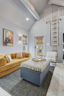 a living room with a bed and next to a window