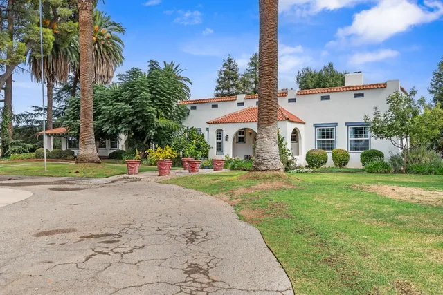 a hallway with couches wooden floor and dining table