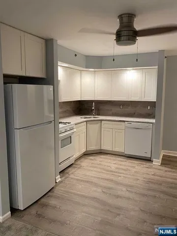 a kitchen with stainless steel appliances granite countertop a refrigerator a sink and a stove