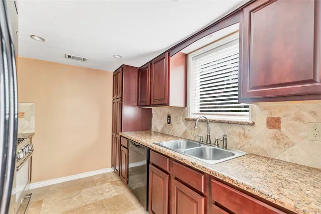 a kitchen with stainless steel appliances granite countertop a sink and a window