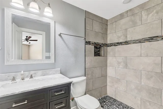 a bathroom with a granite countertop sink toilet and shower