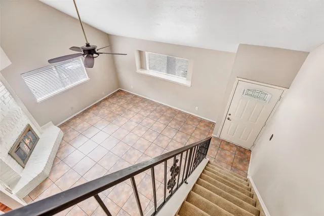 a view of a hallway to a house with wooden floor and stairs